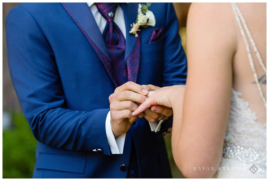 groom putting ring on bride