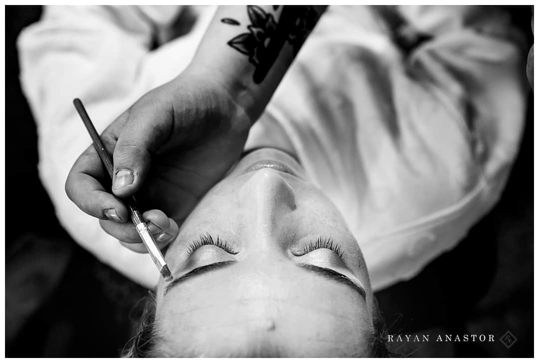 bride having her makeup completed