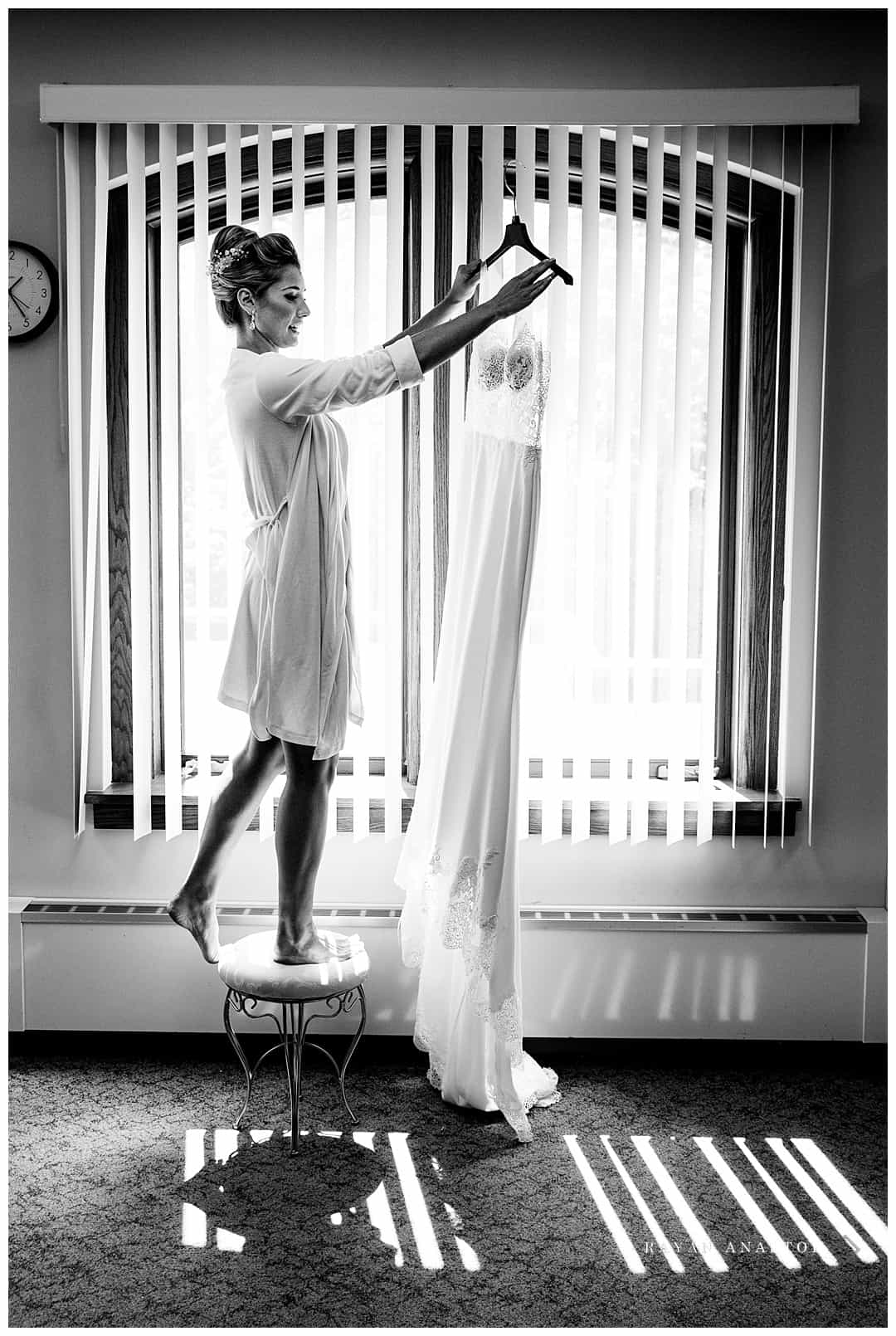 bride getting her wedding dress down from hanger