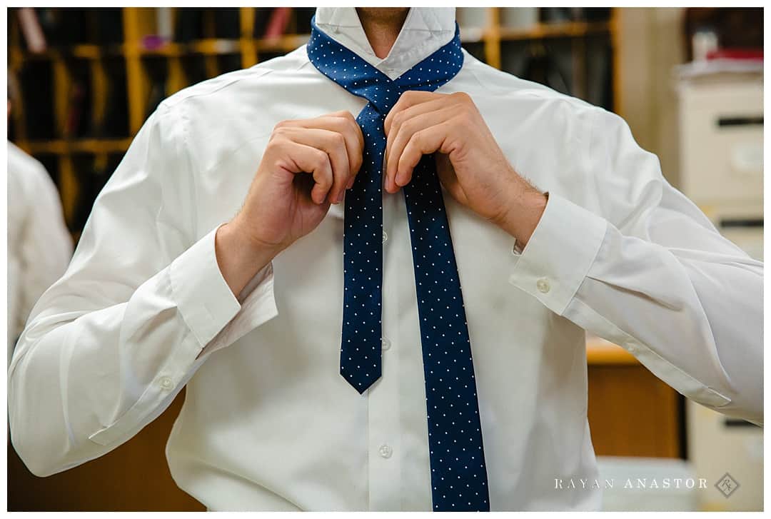 groom tying tie