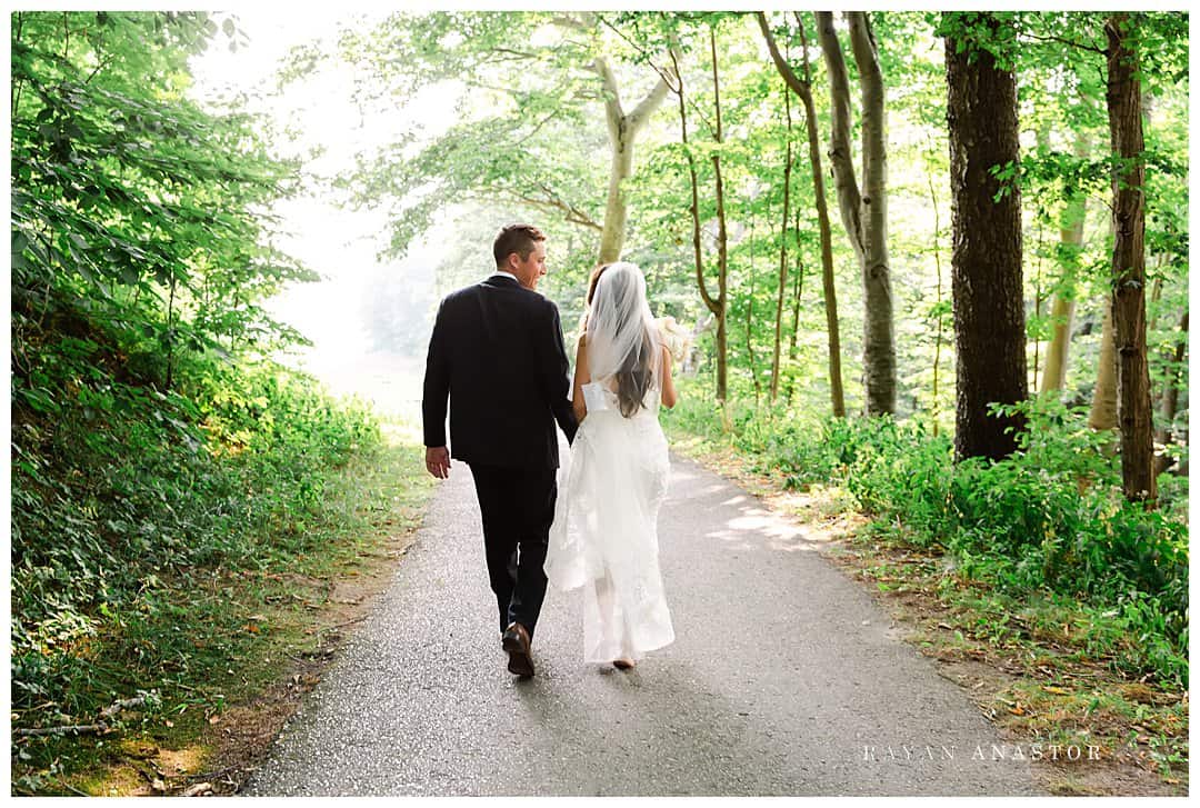 groom and bride walking through Crystal Downs Golf Club