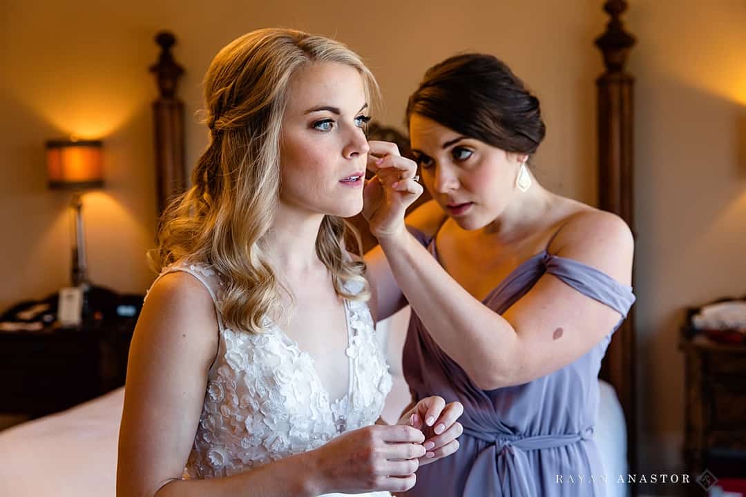 sister putting on brides earrings