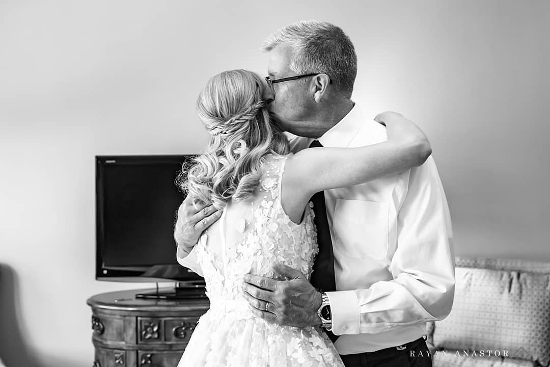 father kissing daughter before wedding