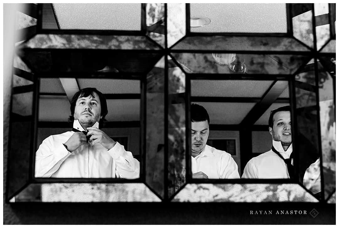 groom and groomsmen tying bowties