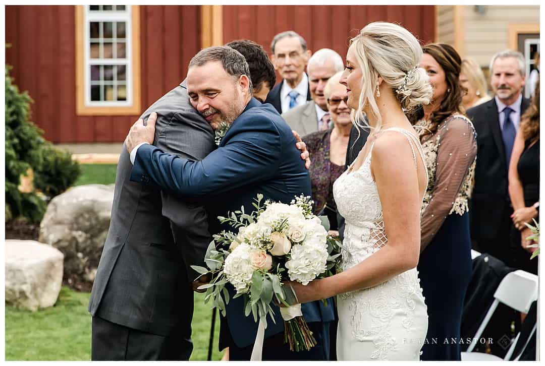 groom and father of bride hugging