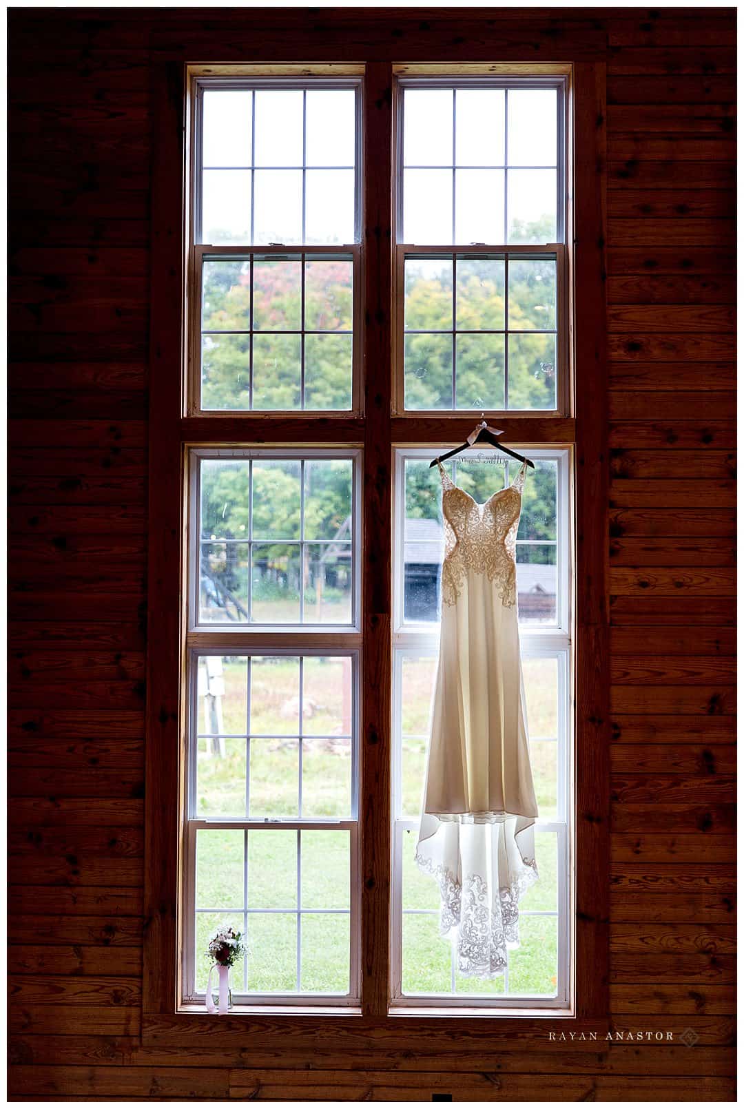 wedding gown hanging from window in ski lodge