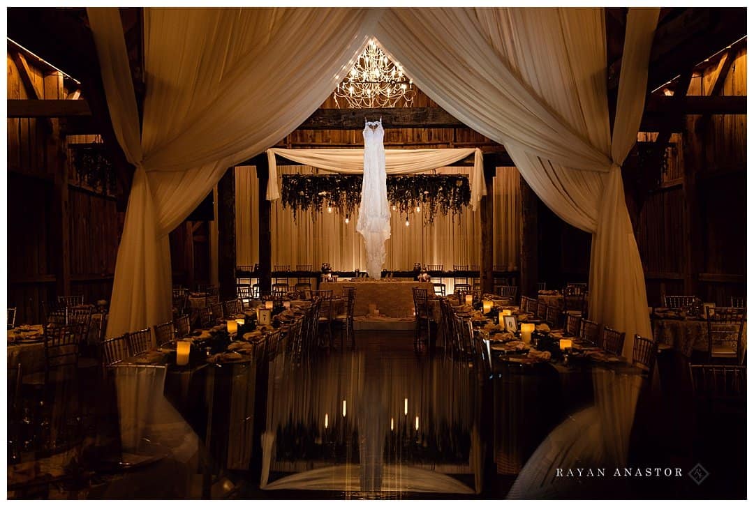 wedding gown hanging from a rafter in a barn