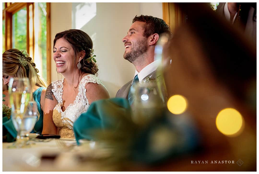bride and groom laughing at toasts