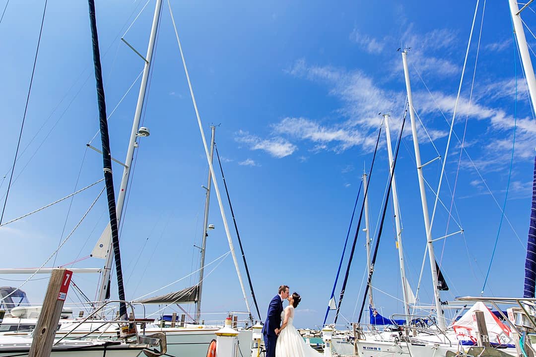bride and groom at the Leland Marina with the sailboats