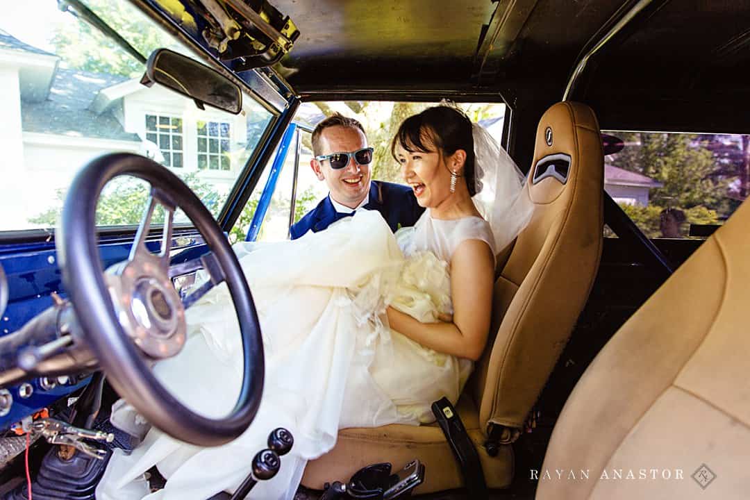 groom putting bride in car after wedding