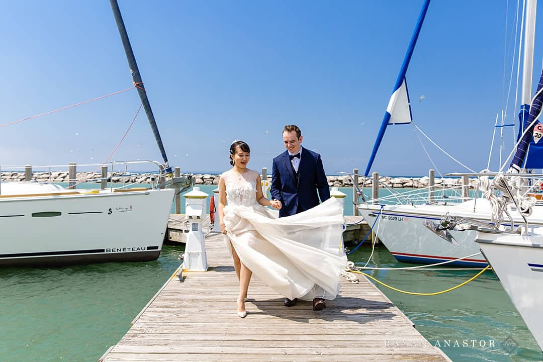 bride and groom walking through the Leland Marina