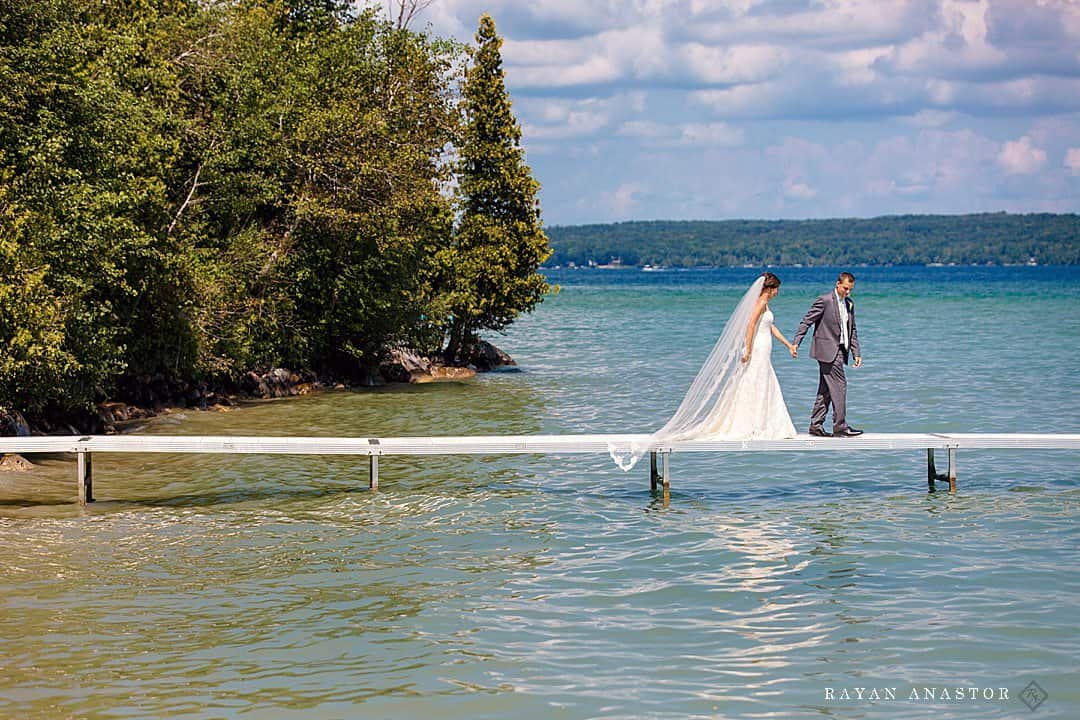 bride and groom walking a dock