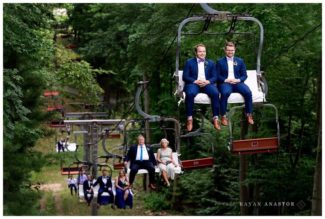groom riding chair lift to wedding at the homestead resort