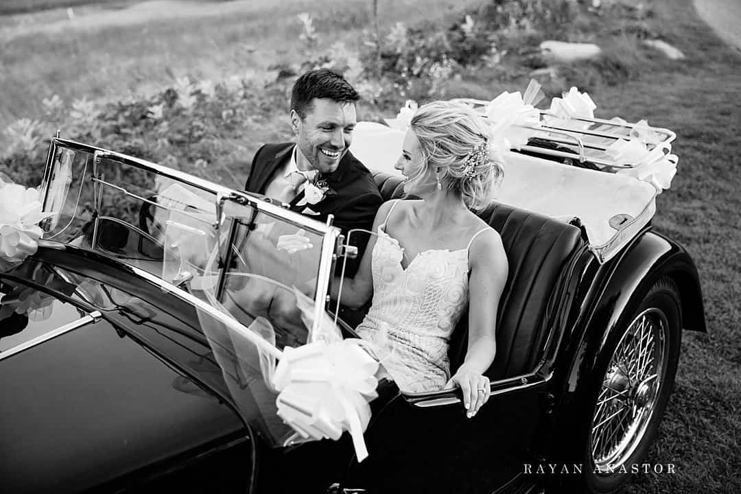 bride and groom leaving in classic car