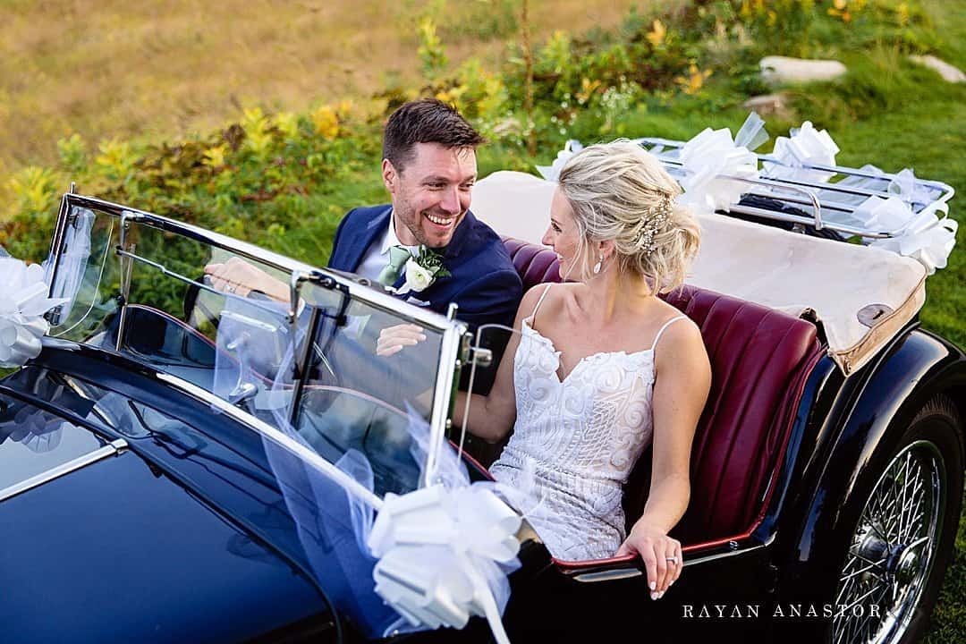 couple arrive to reception in classic car