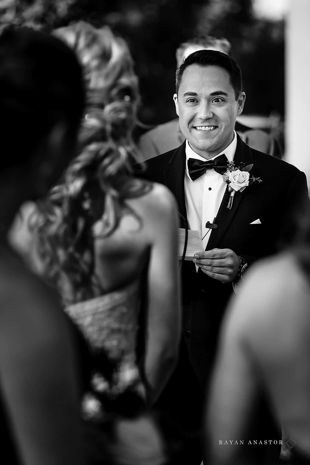 groom smiling at bride during vows