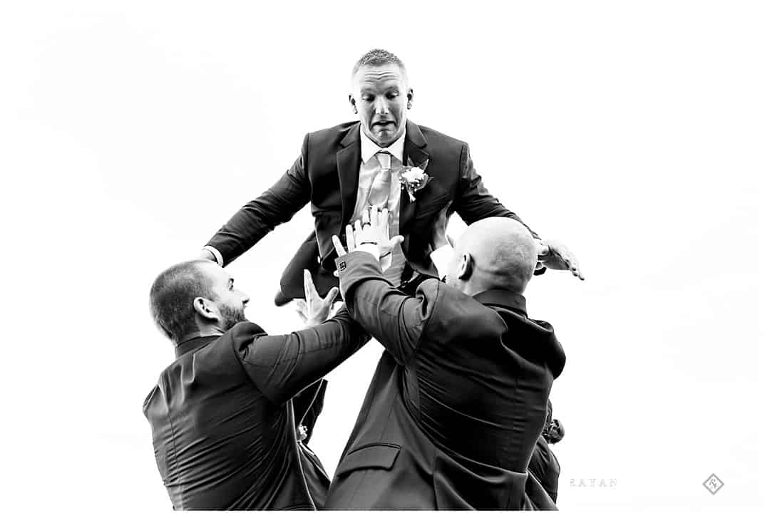 groom getting tossed in air