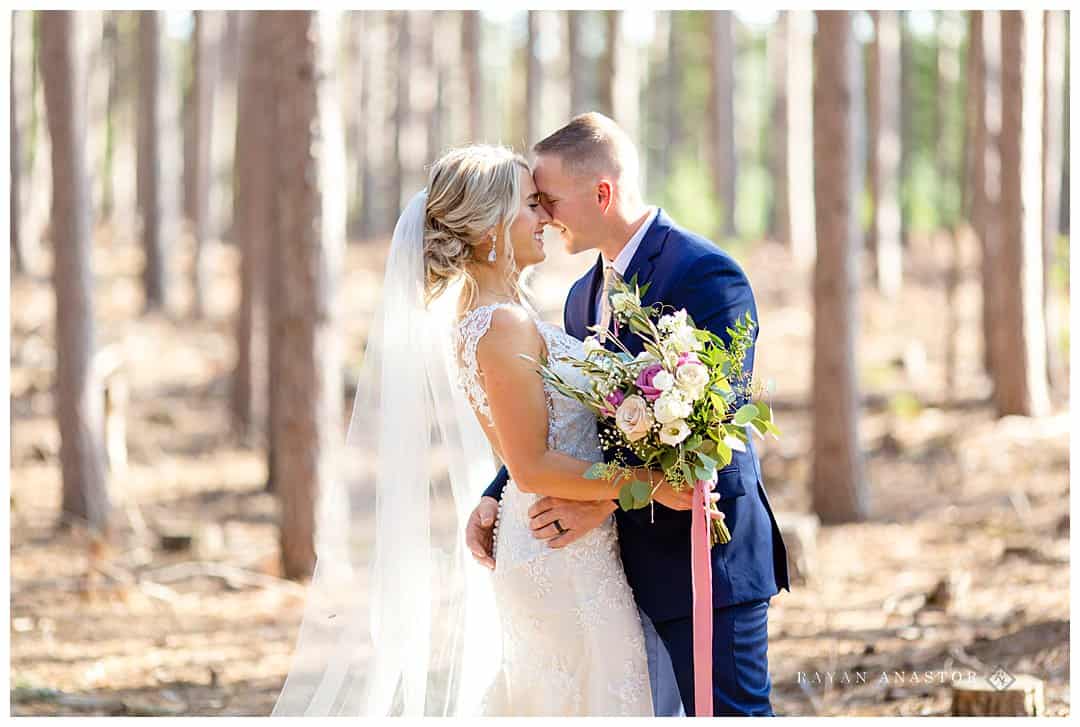 bride and groom in pine trees at Bluebridge events centre