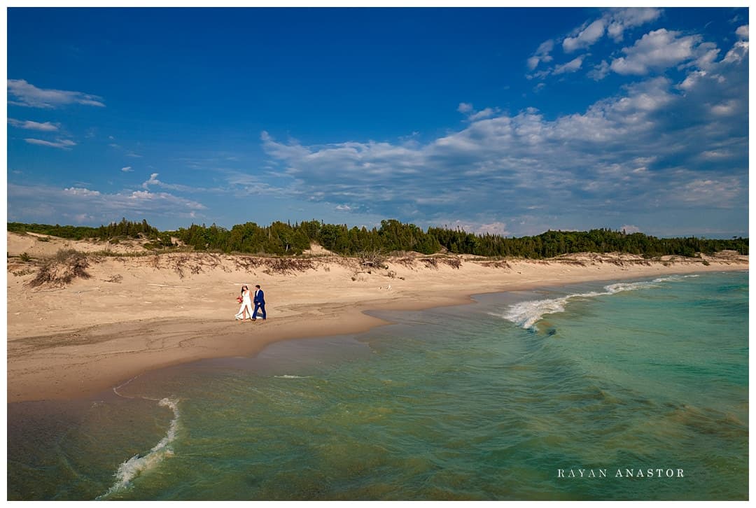 bride and groom walking on Lake Michigan after wedding