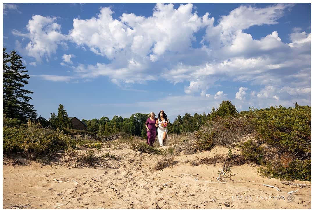 bride walking through dunes to her wedding