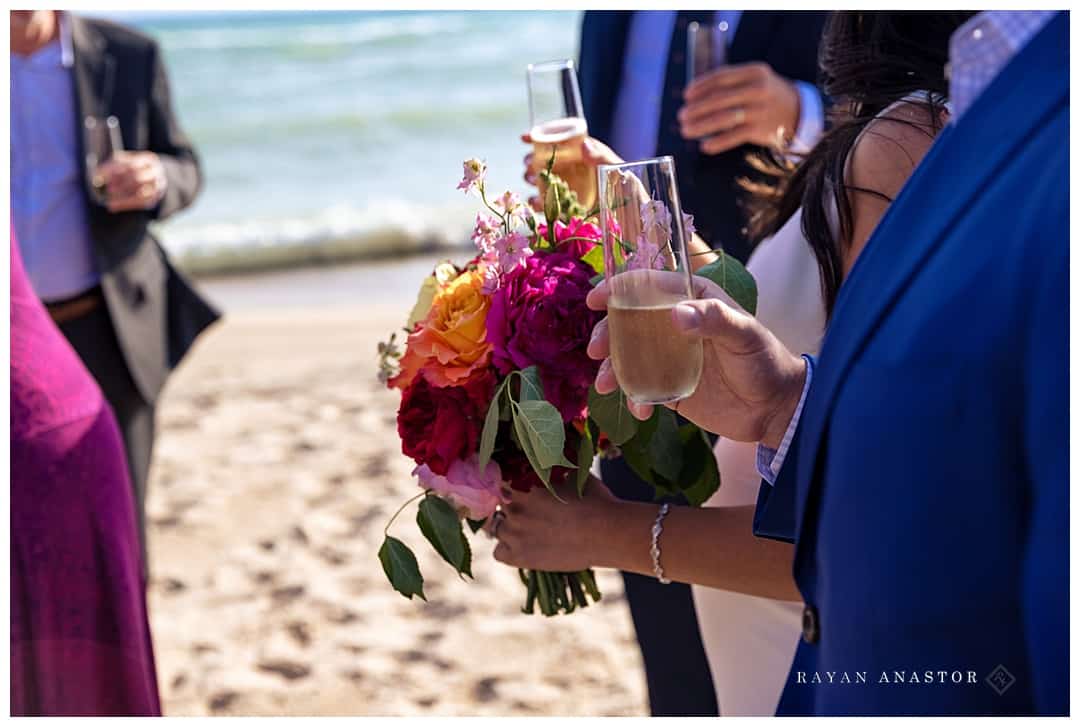 champaign toasts on beach after elopement