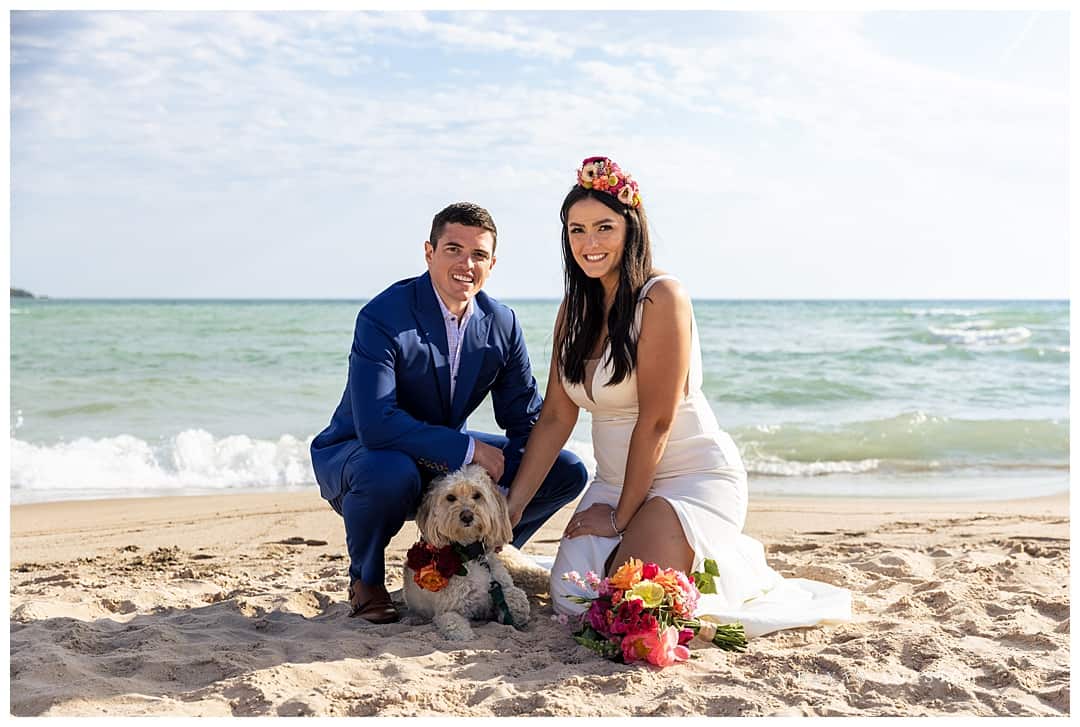 bride and groom with their puppy on the beach
