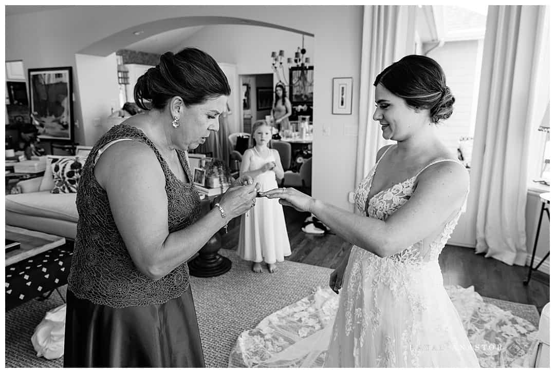 mom helping bride with jewelry
