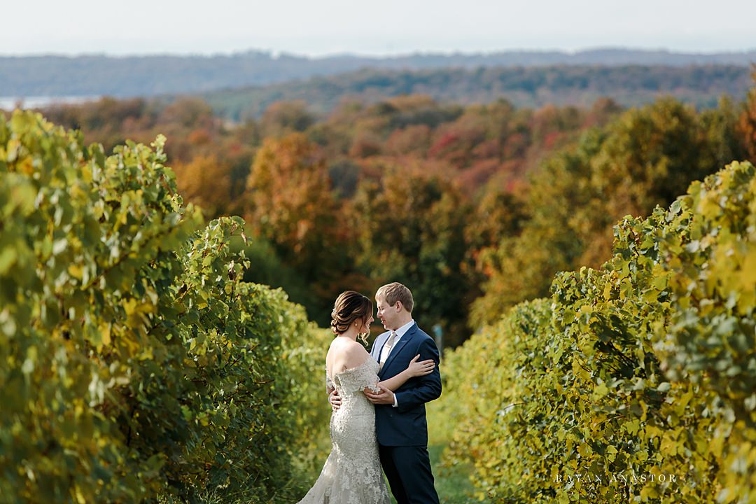 bride and groom strolling through Chateau Grand Traverse in the fall