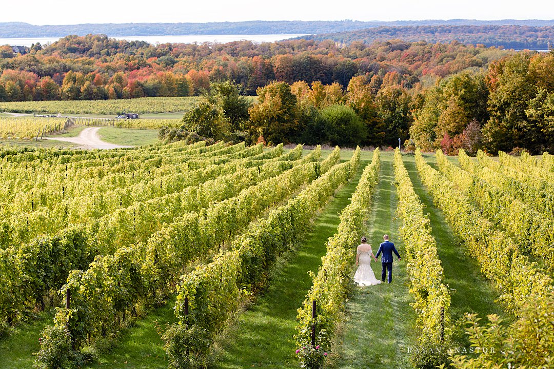 bride and groom wandering chateau Grand Traverse in the fall