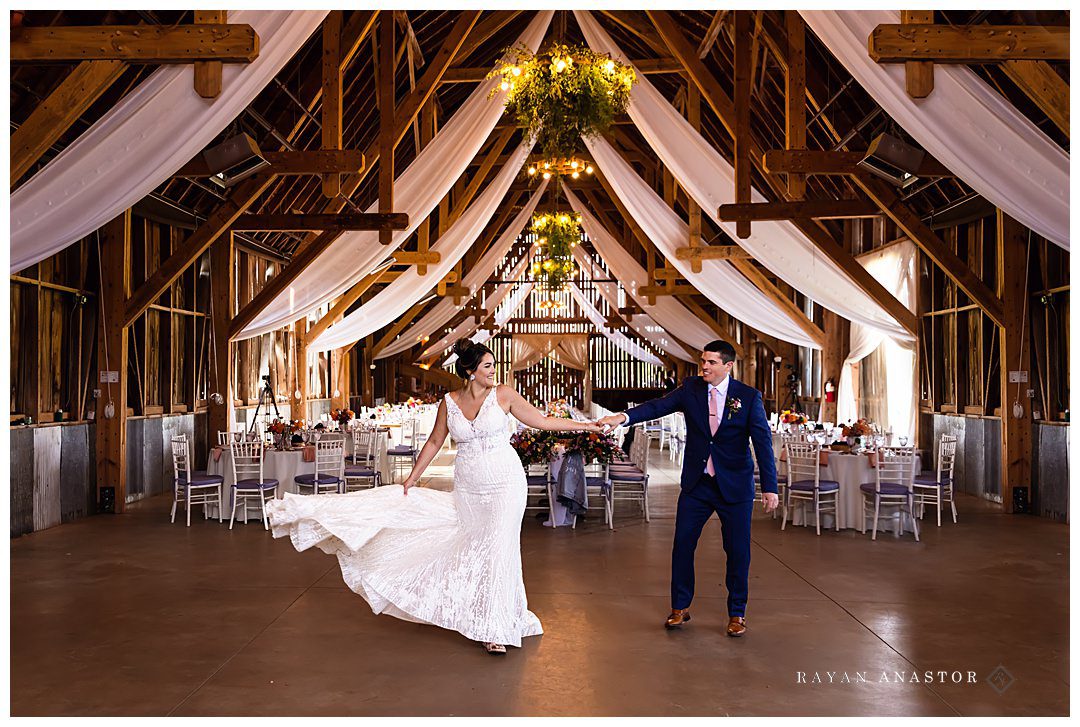 Bride and groom dancing in barn