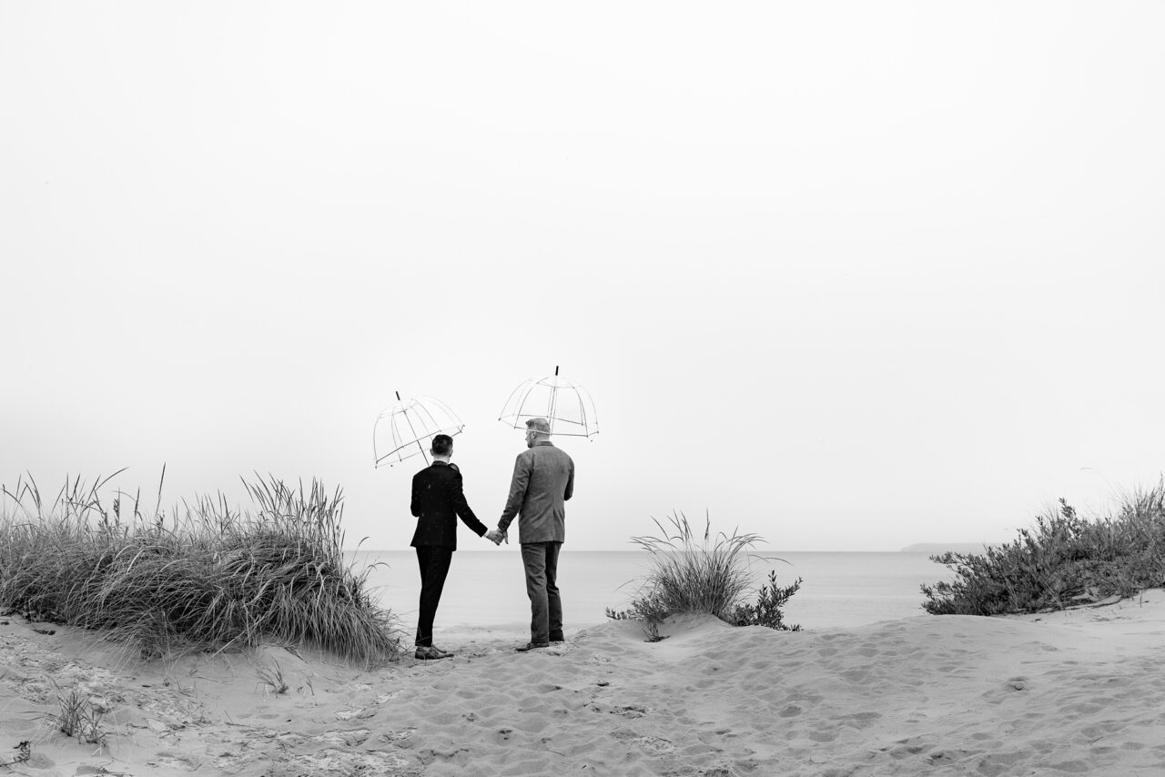 Grooms taking a walk on Lake Michigan in the Rain before the wedding